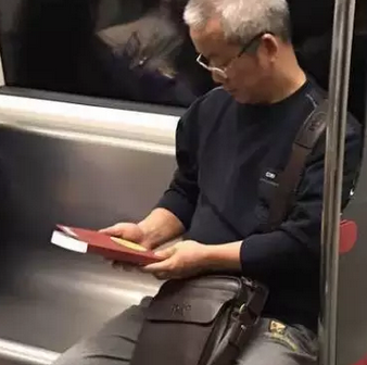 等地铁时,做座位旁的老人忍不住拿起书籍掀起来看   "丢书大作战"
